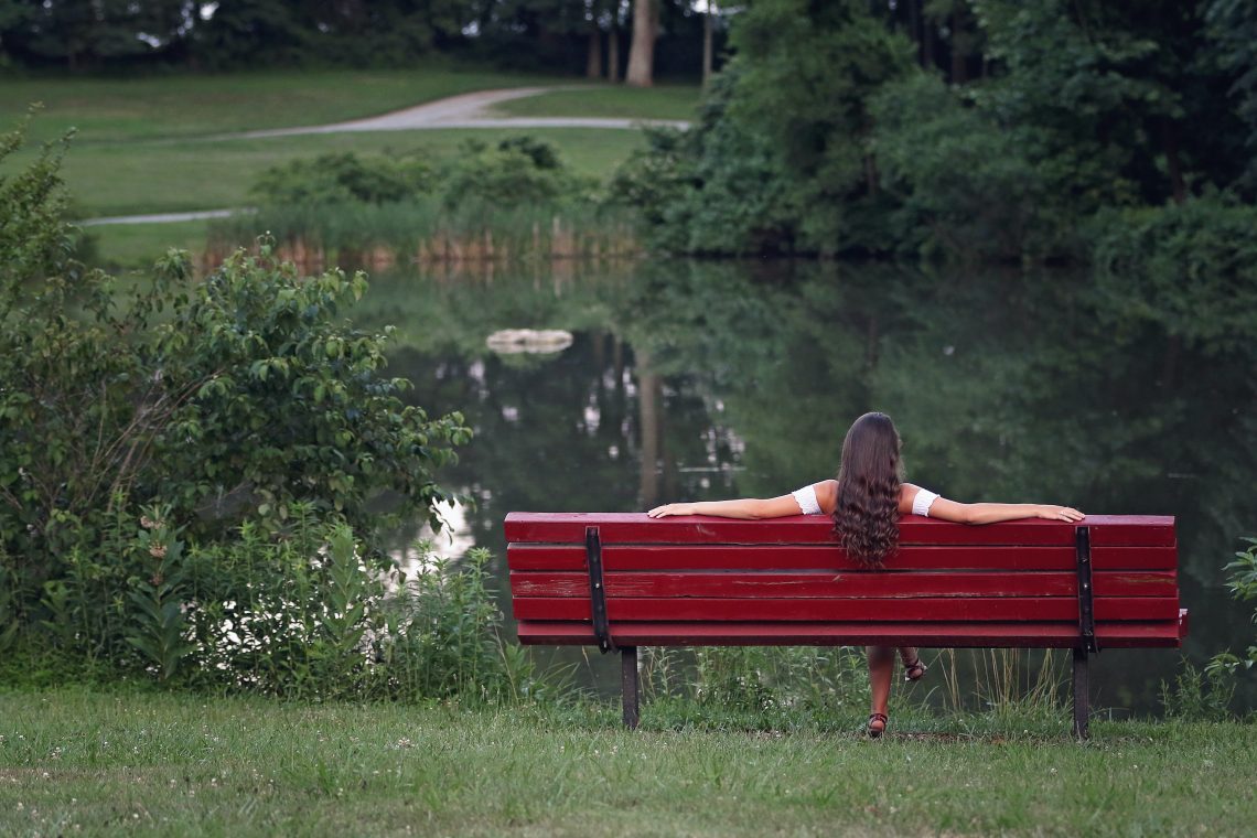 Mujer sentada en banco en la naturaleza