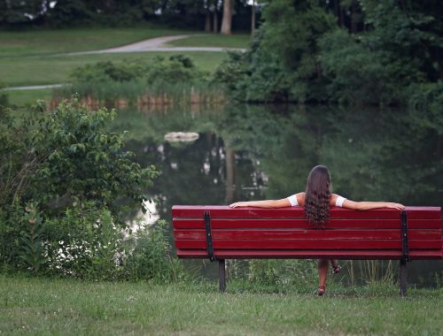 Mujer sentada en banco en la naturaleza