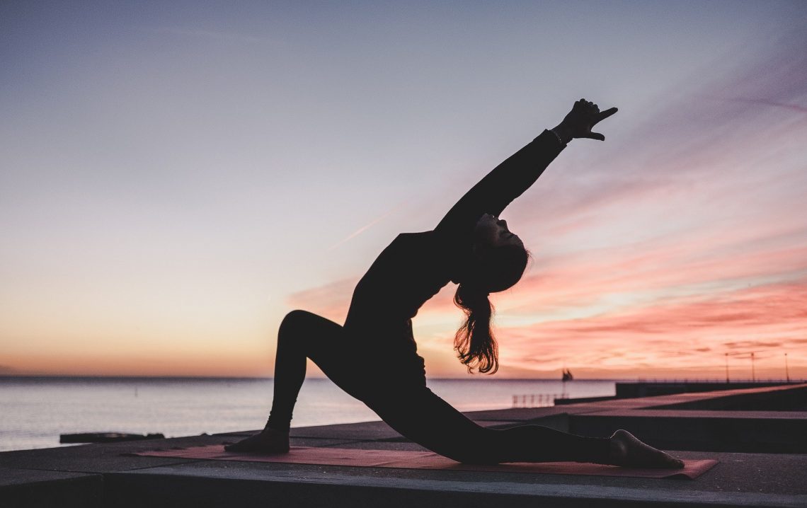 Chica haciendo yoga al atardecer